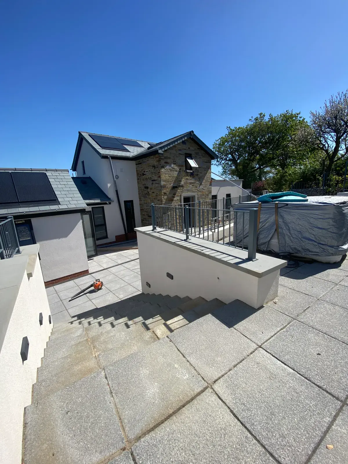 Contemporary home in silicone render with a paved patio, by PureRend